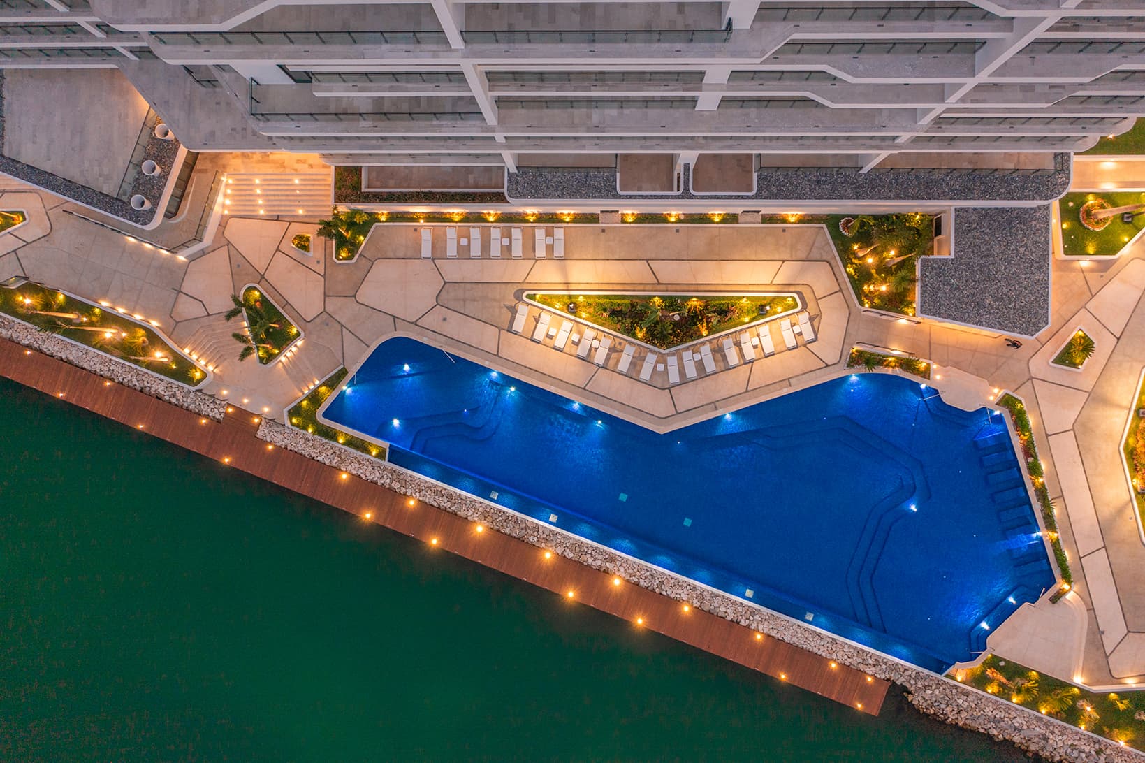 Vista cenital de la alberca y el muelle de un condominio sobre la marina de Puerto Cancún